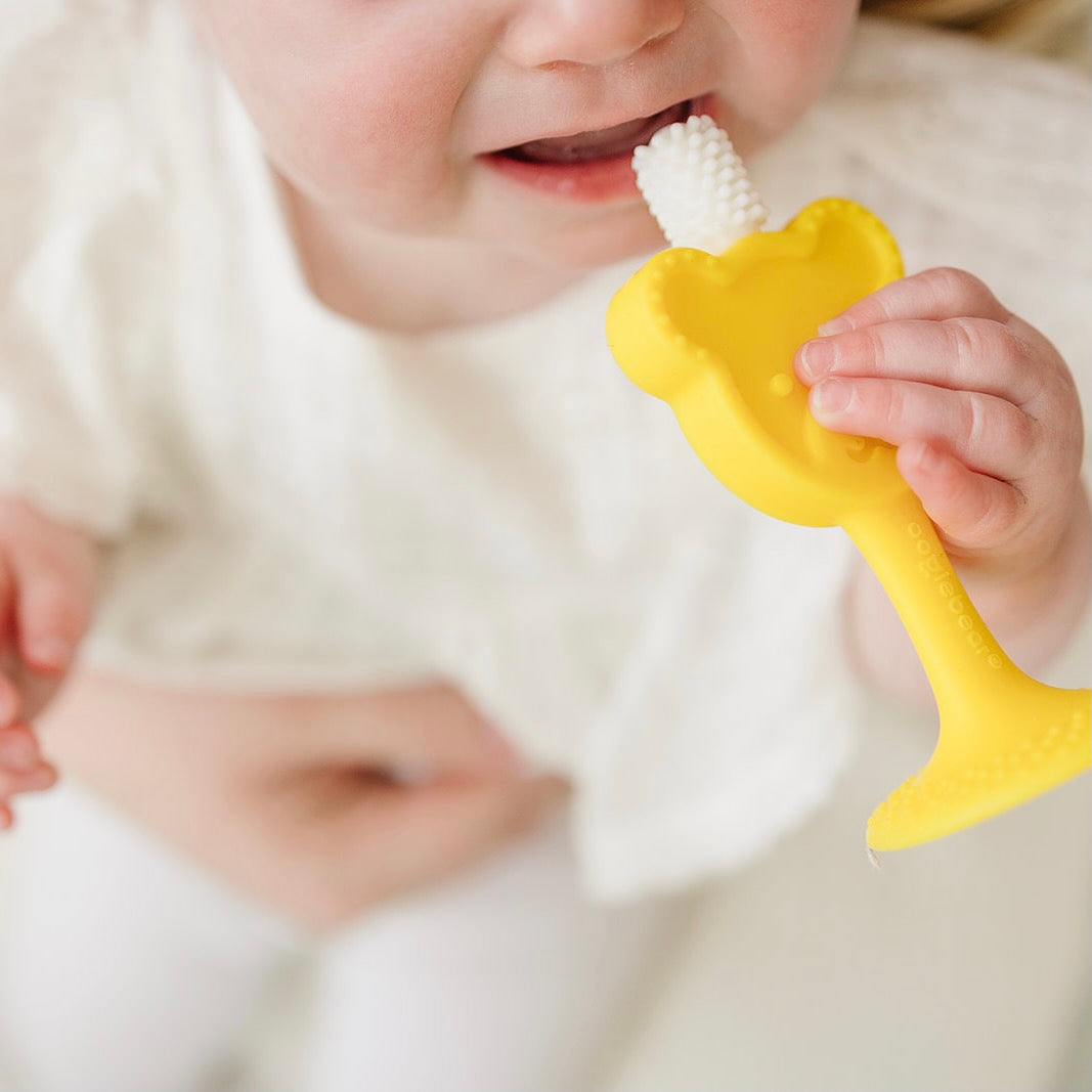 baby holding oogiebear 360° teething toothbrush